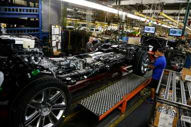 Workers put wheels at the General Motors Plant in Arlington, Texas May 1, 2015. (Nathan...