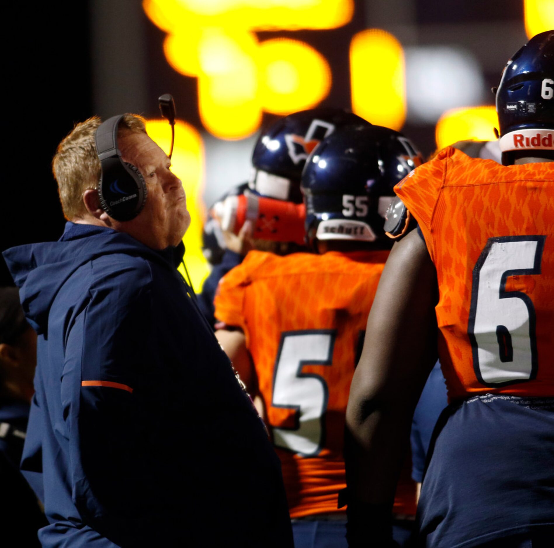 Sachse head coach Mark Behrens glances toward a video screen as his assistants share game...