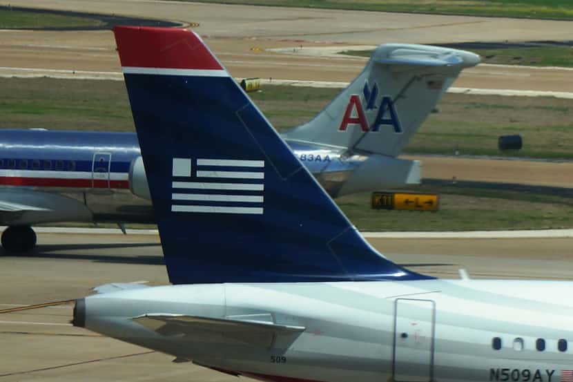  American Airlines and US Airways cross paths at Dallas/Fort Worth International Airport in...