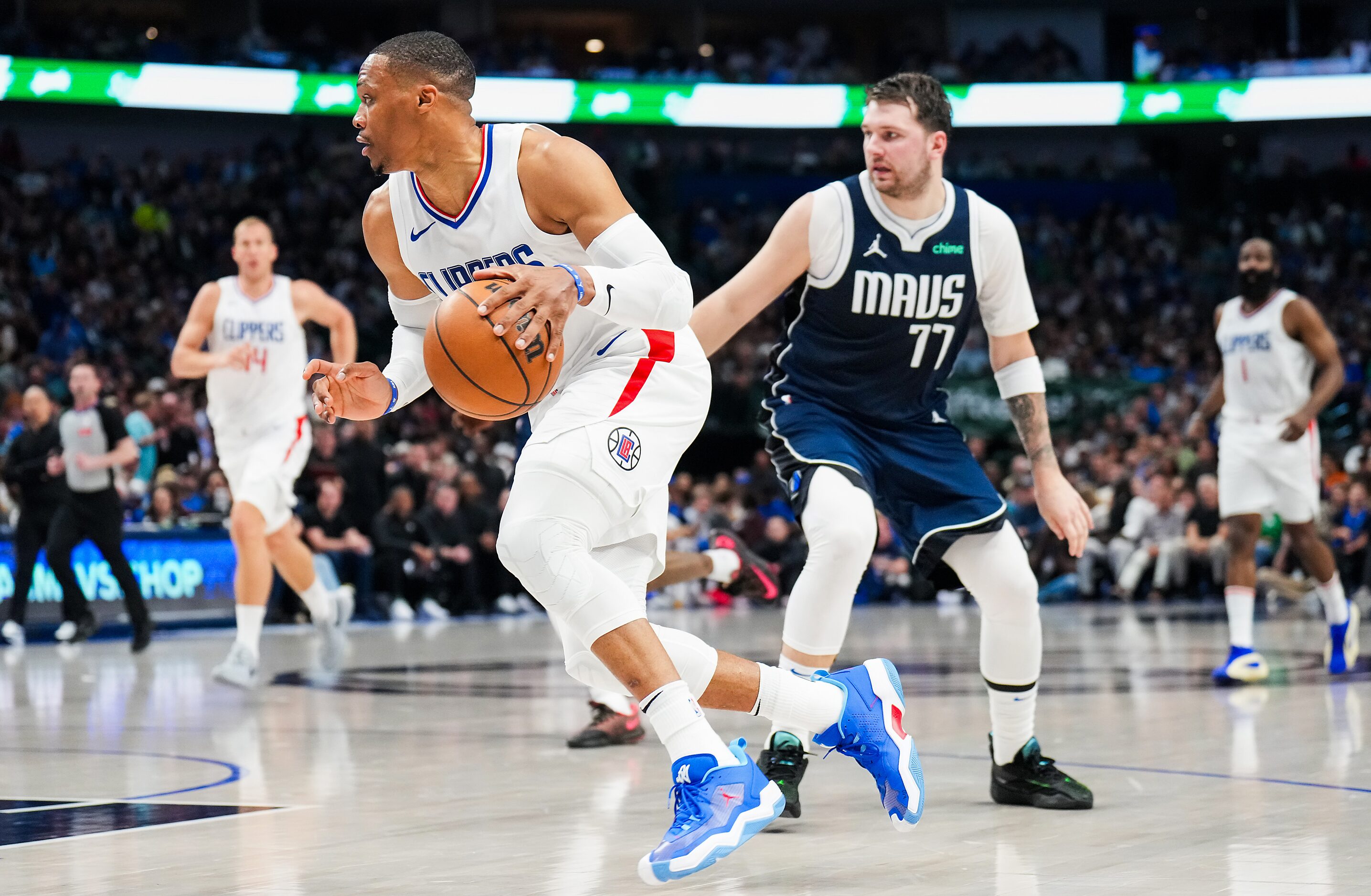 LA Clippers guard Russell Westbrook (0) blows past Dallas Mavericks guard Luka Doncic (77)...