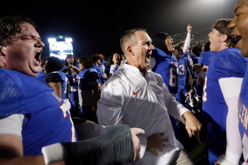 Allen head coach Lee Wigginton and his players celebrate their overtime win over Arlington...