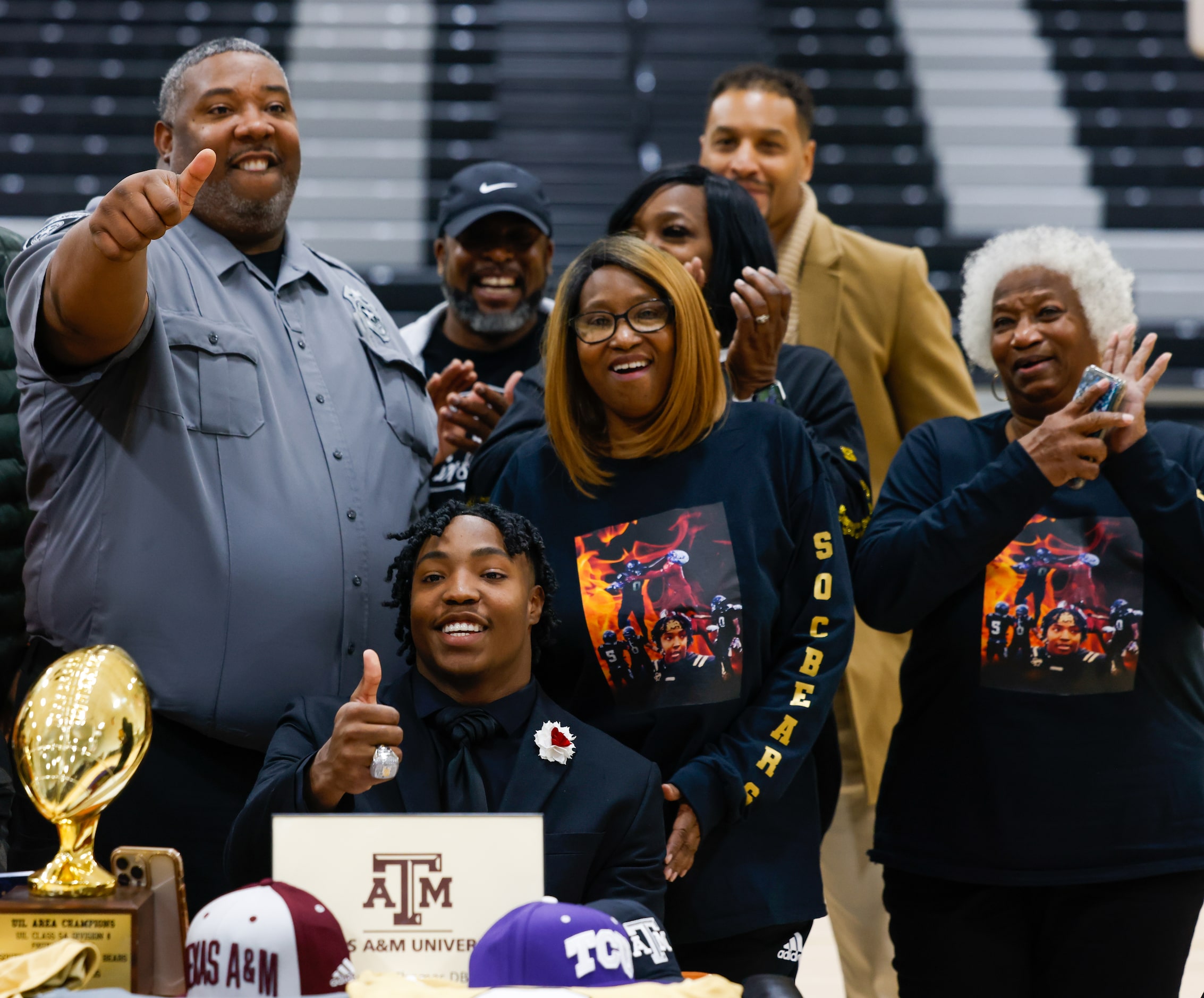 South Oak Cliff football player Jayvon Thomas (center) flashes a thumbs up with family and...