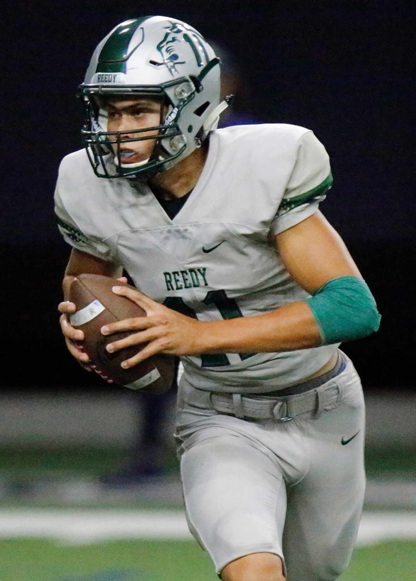 Reedy High School quarterback Jalen Kitna (11) rolls out during the first half as Reedy High...