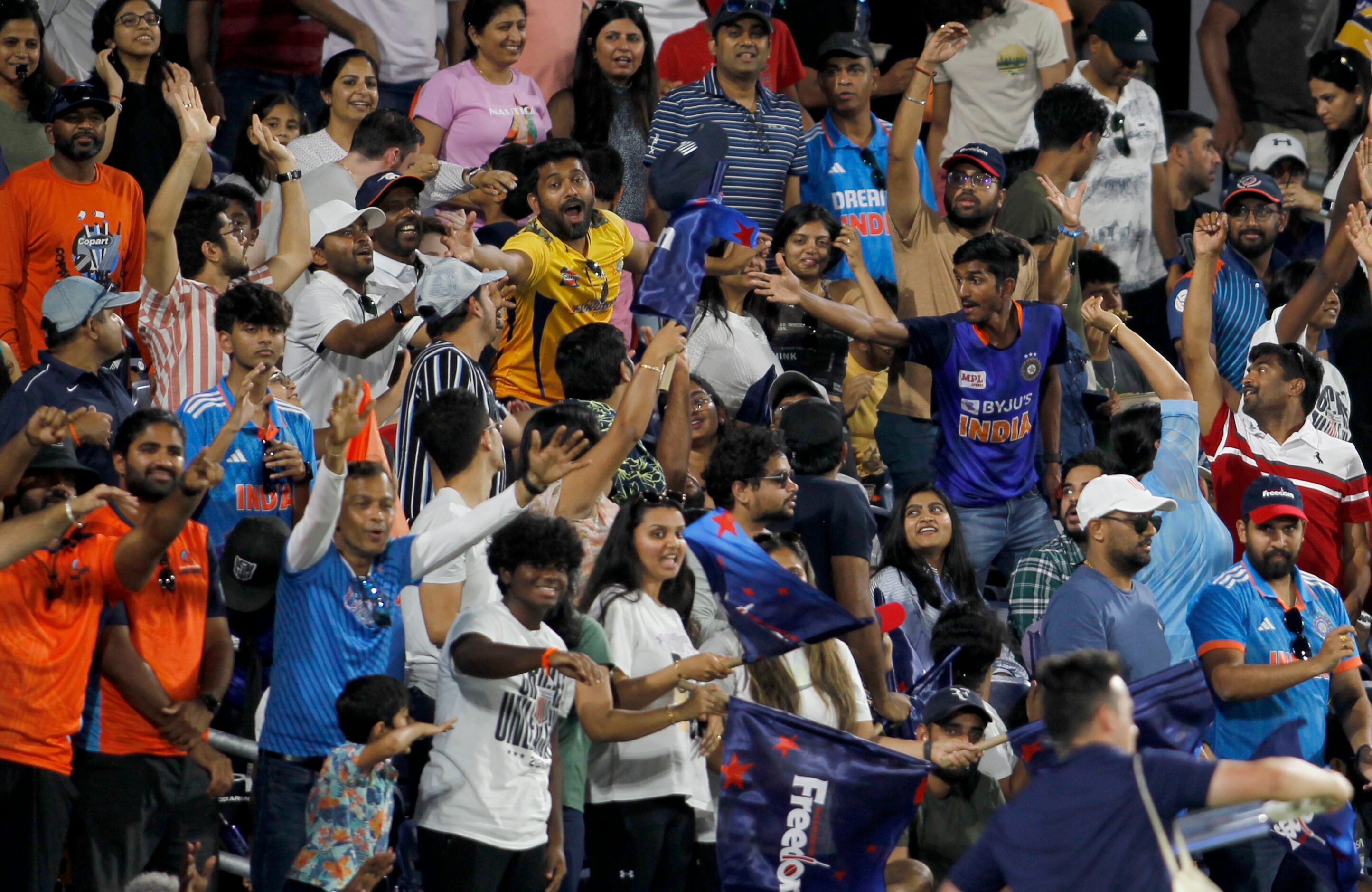 Fans scramble to grab a souvenir cap thrown into the crowd during a strategic time out of...