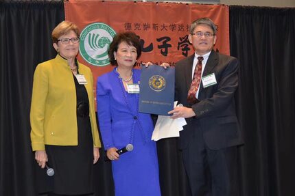 State Reps. Linda Koop (left) and Angie Chen Button present Dr. Ming Dong Gu with a...