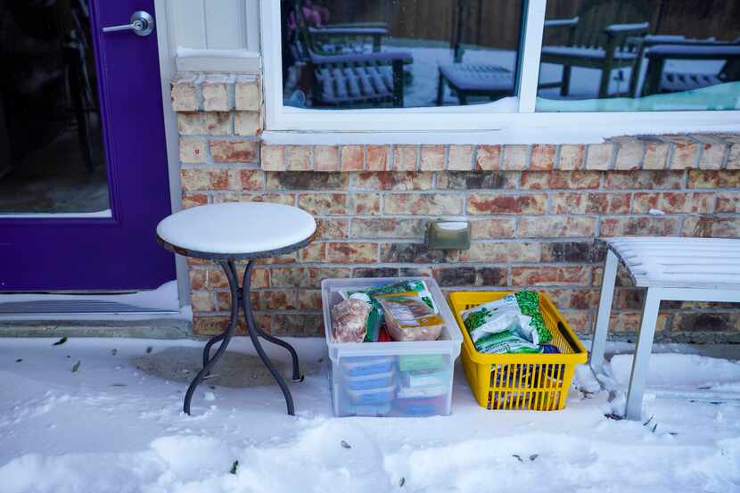 Contents of a home freezer rest in the snow on the outside patio of a home in Richardson...