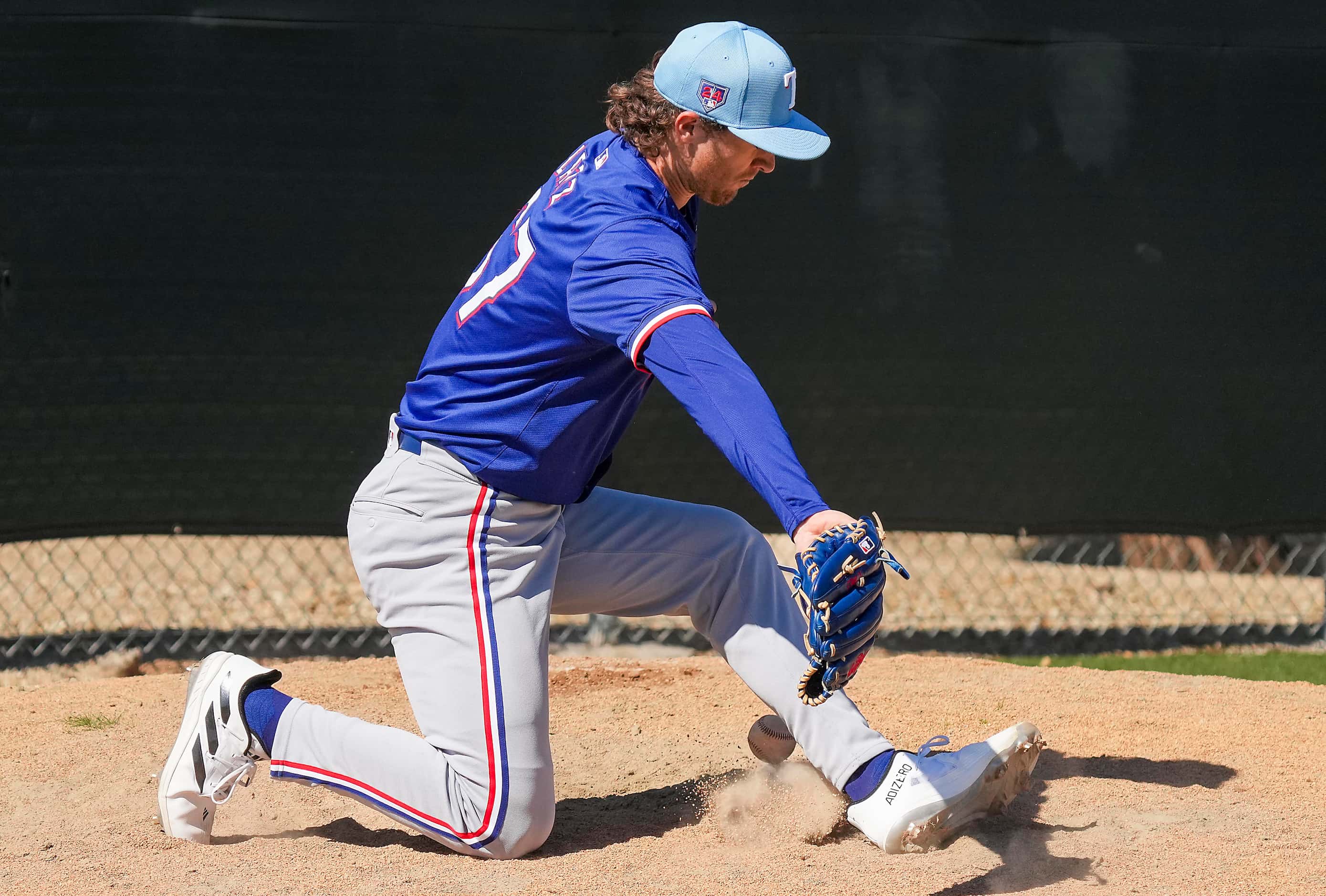 Texas Rangers pitcher Jake Latz tries to make a play on a sharp grounder back to the mound...
