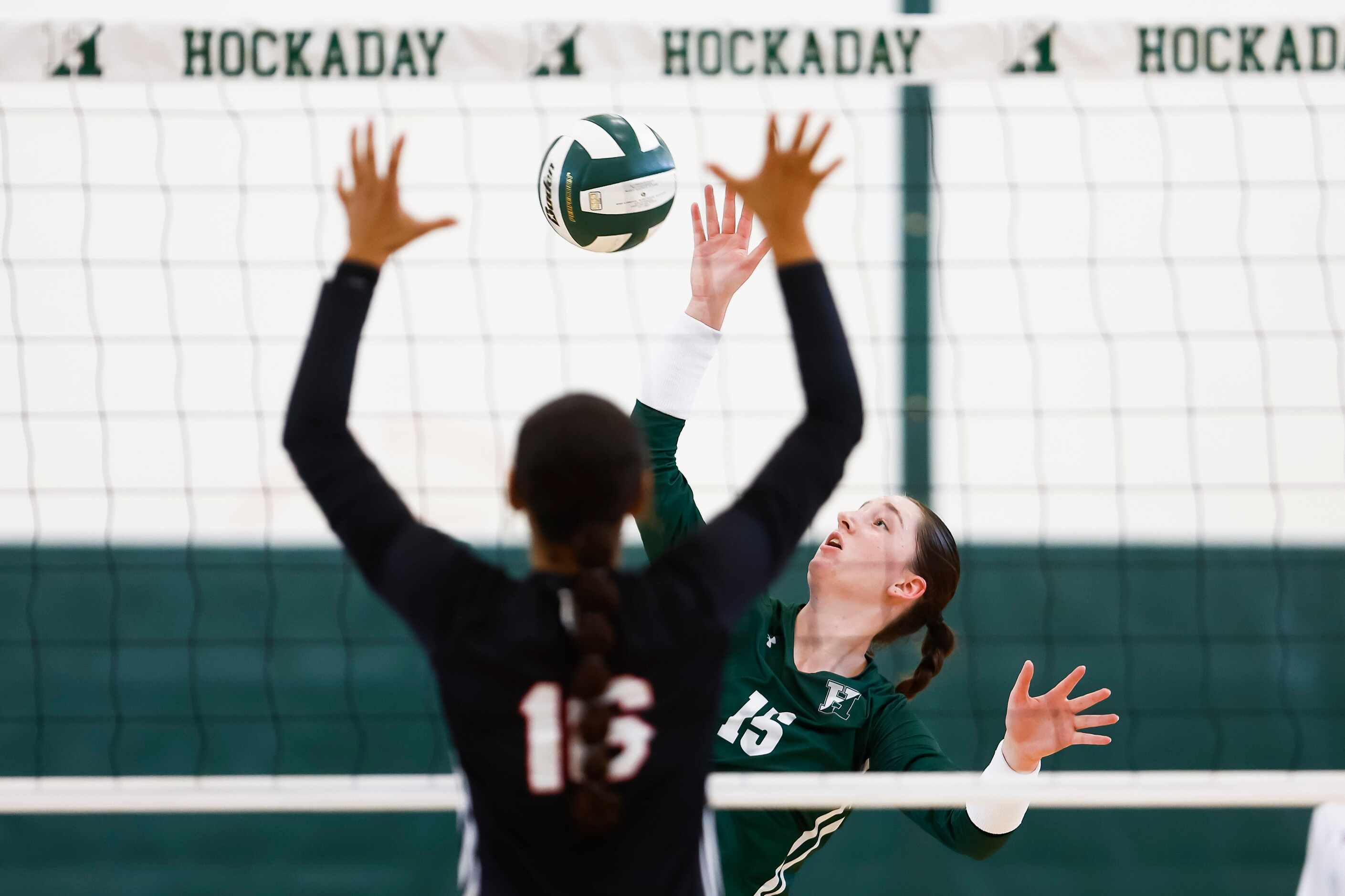 Hockaday junior middle blocker Olivia Wayne (15) hits the ball over the net as Love Joy...