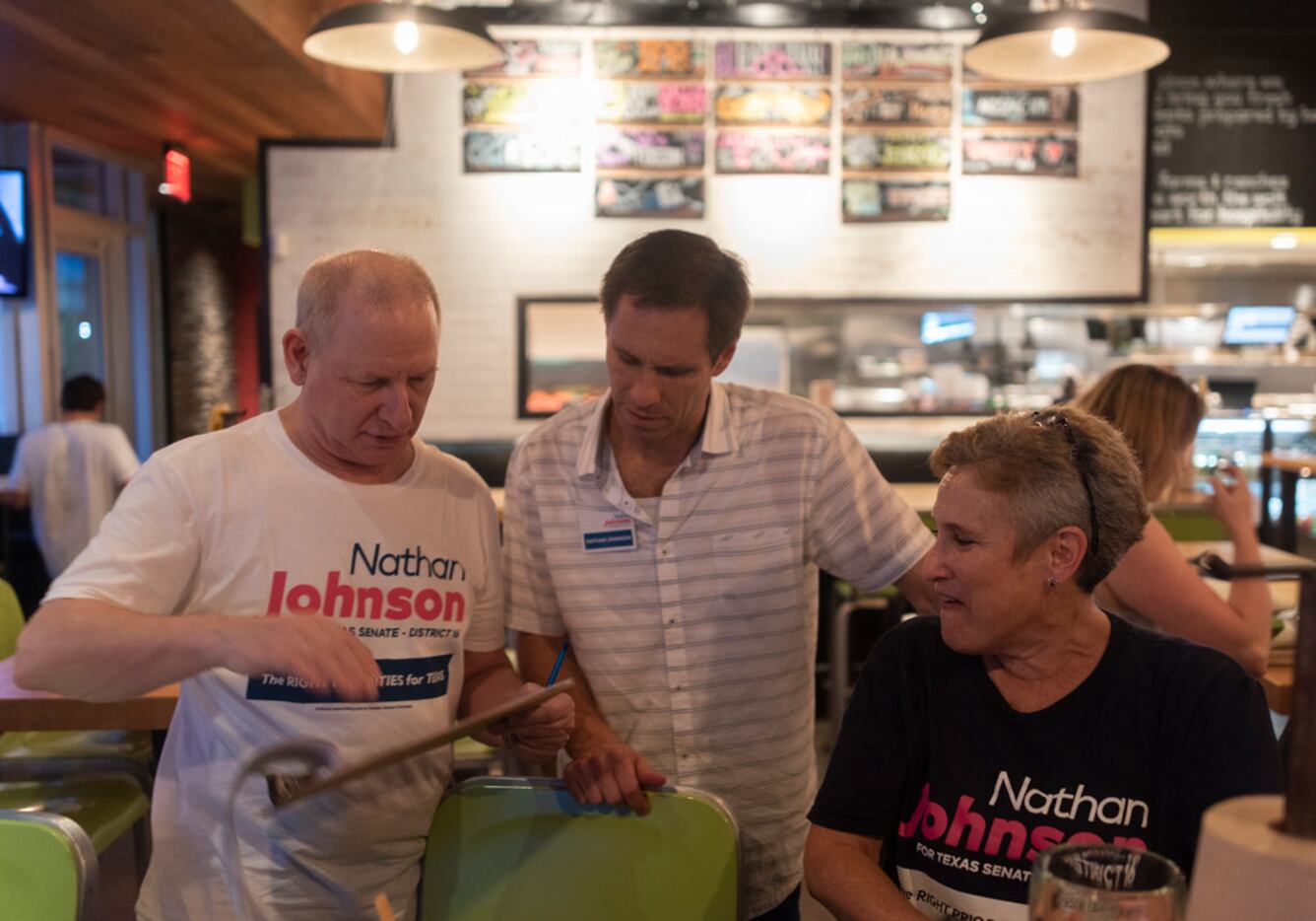 Nathan Johnson, center, talks with Brad Carafiol, left, at Hopdoddy Burger Bar after he and...