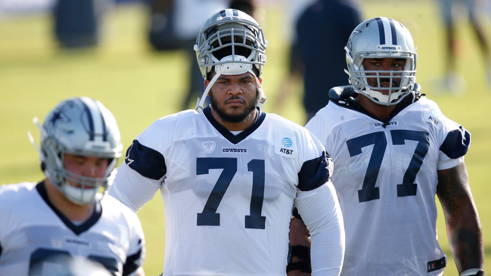 Cowboys offensive tackles La'el Collins (71) and Tyron Smith (77) watch a drill in progress...