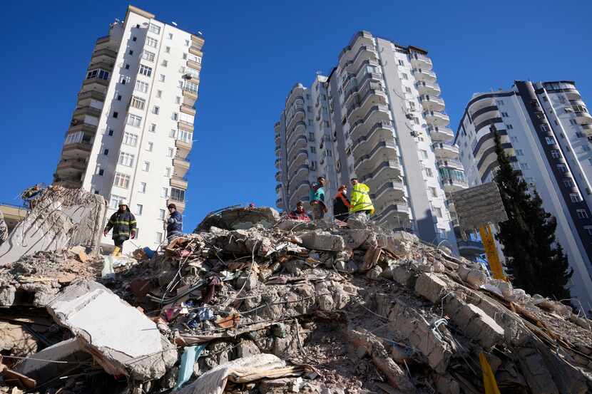  Equipos de emergencias buscan a personas entre los escombros de un edificio destruido en...