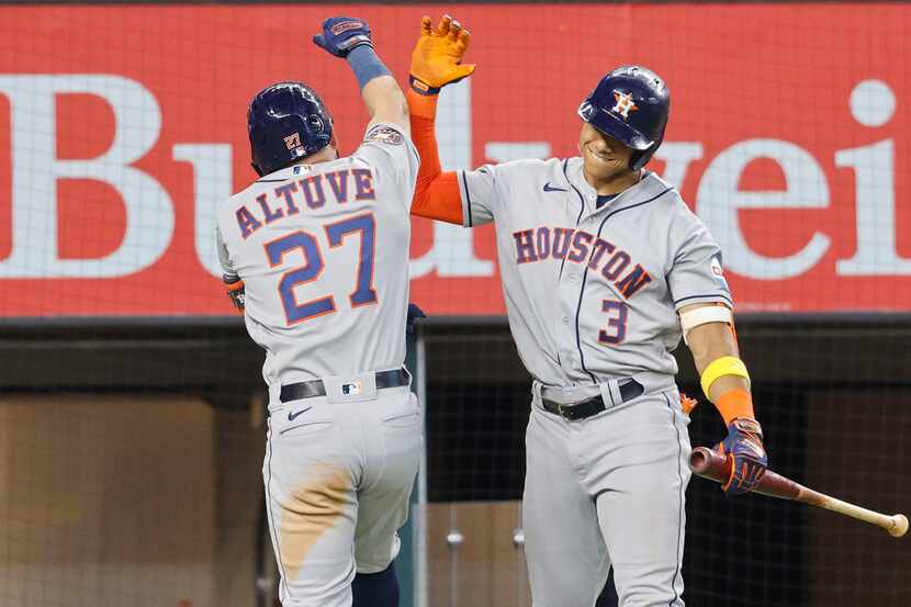 Houston Astros second baseman Jose Altuve (27) gets a high-five from his teammate shortstop...
