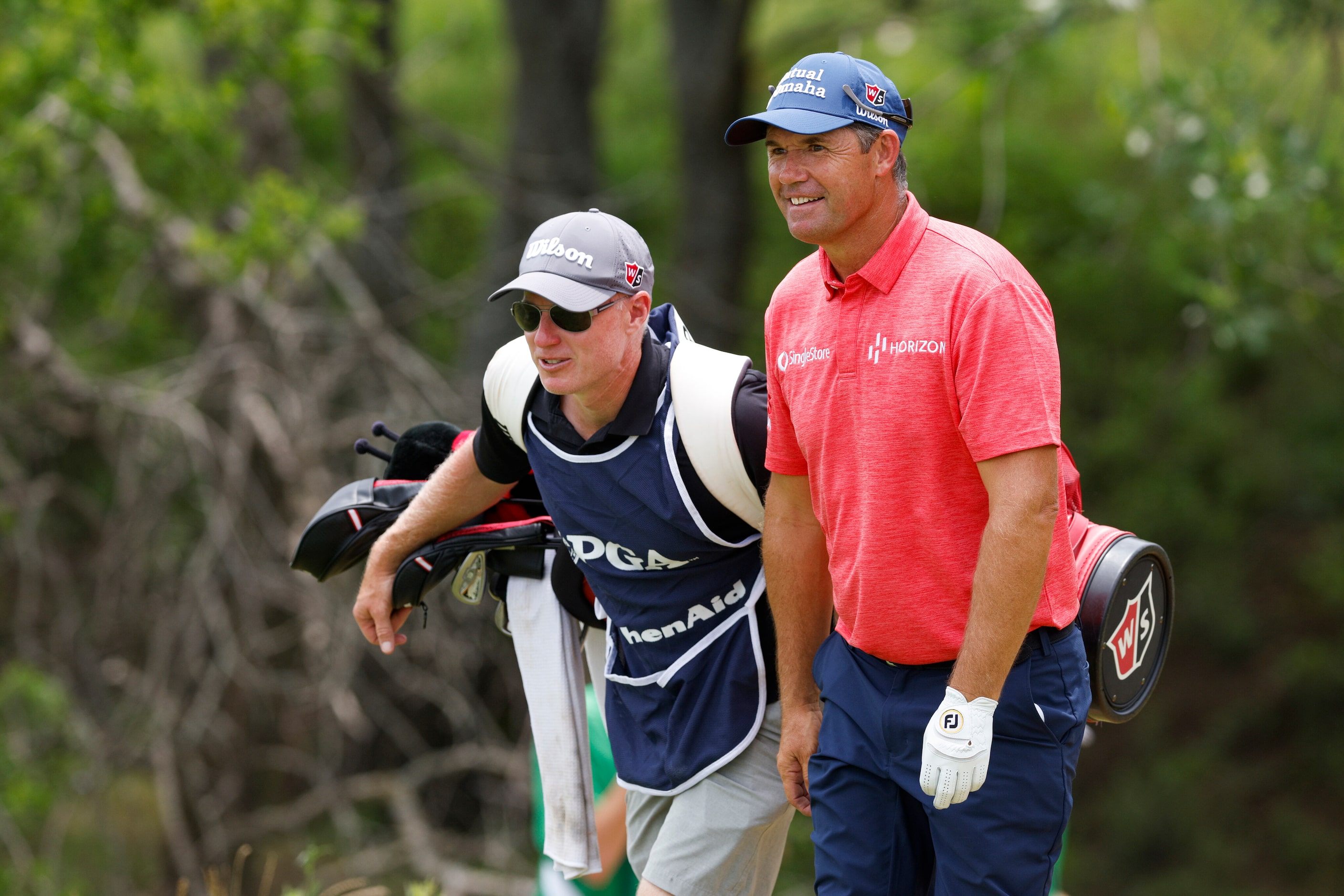 Padraig Harrington of Ireland walks with his caddie Ronan Flood on the 18th hole during the...