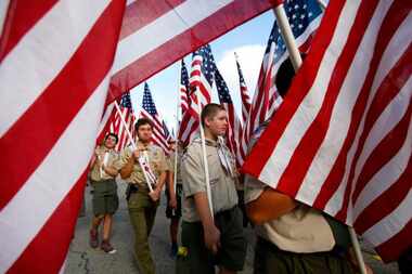 
Boy Scout Brenden Bayes, of Troop 57 in Garland, holds an American flag as he marches with...