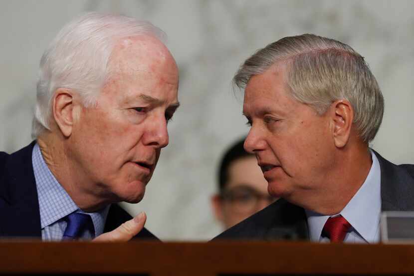 Senate Majority Whip John Cornyn confers with Sen. Lindsey Graham, R.-S.C., during a hearing...