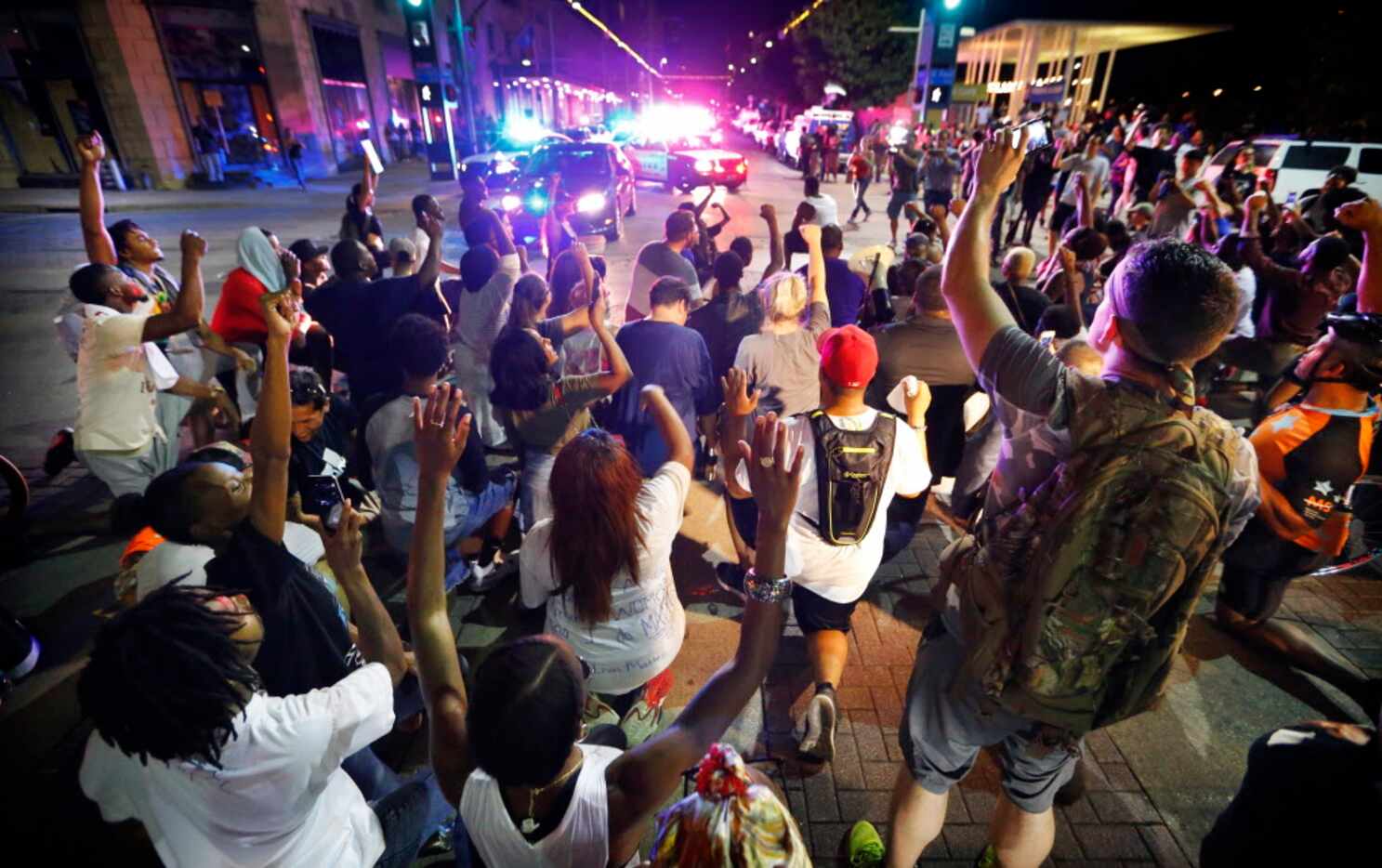 Like San Francisco quarterback Colin Kaepernick, protesters take a knee in the intersection...