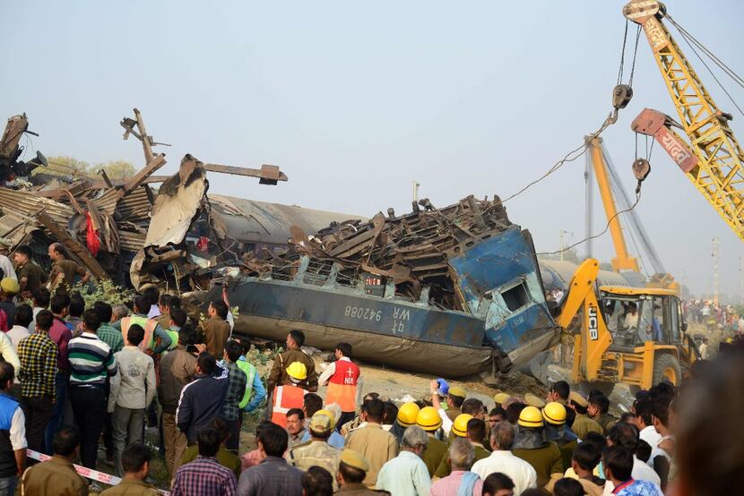 Indian rescue workers search for survivors in the wreckage of a train that derailed near...