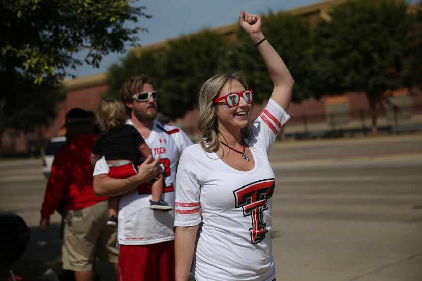 Texas Tech Red Raiders fan Betty Harris, of Allen, Texas, cheers while playing corn hole...