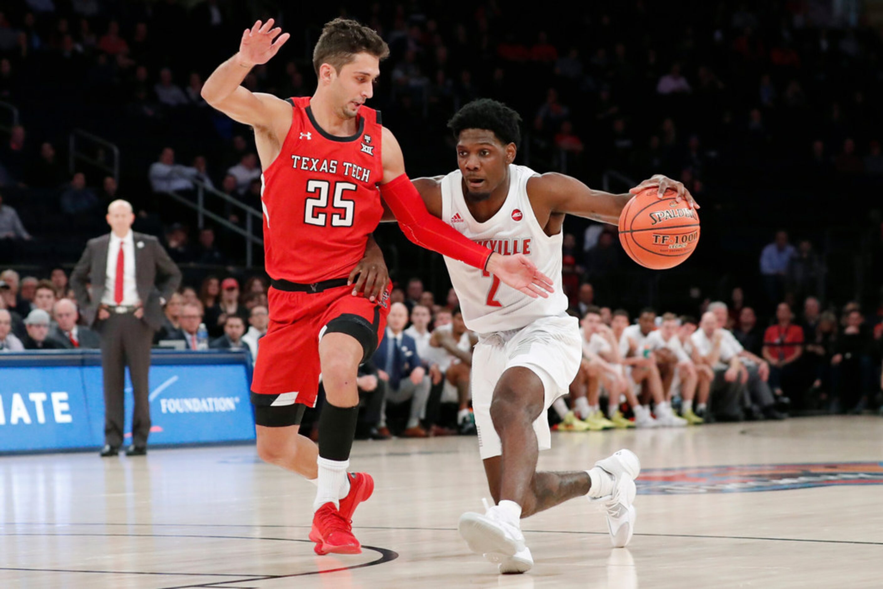 Texas Tech guard Davide Moretti (25) defends Louisville guard Darius Perry (2) as he drives...