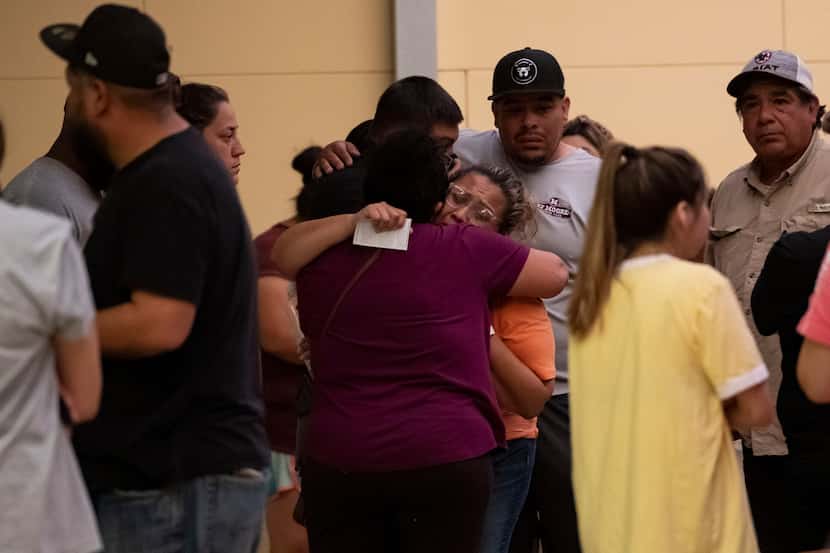 Women hug outside of the SSGT Willie de Leon Civic Center where families were reunited after...