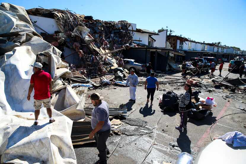People worked on clearing tornado debris at an apartment complex at 9939 Brockbank Drive in...