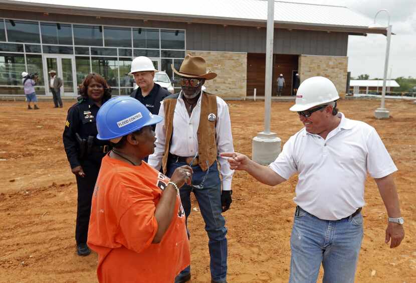 Vonciel Jones Hill, then a Dallas City Council member, talks to Wayne Kirk, far right,...