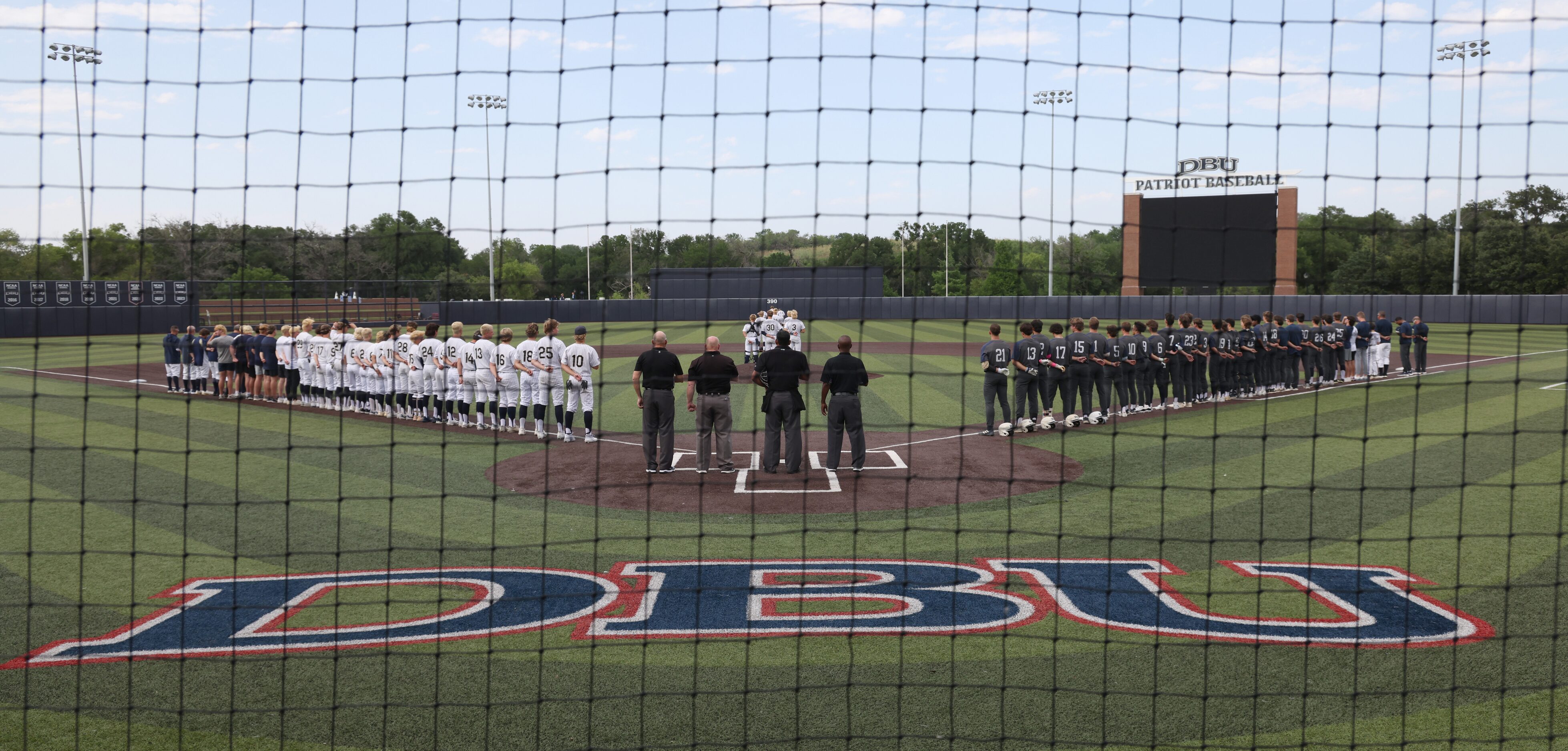 Players from Keller and Flower Mound lineup for the playing of the national anthem just...