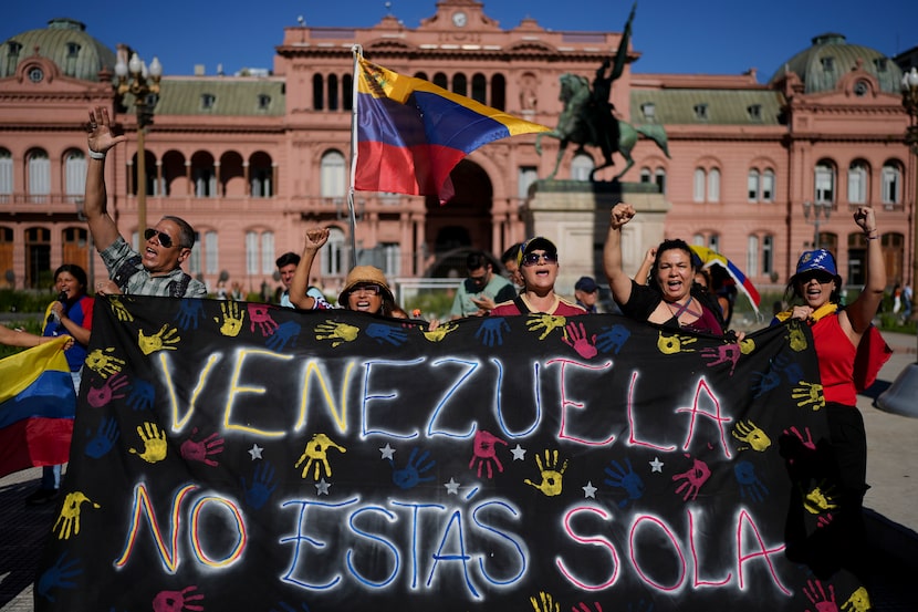 Opponents of Venezuelan President Nicolas Maduro hold a banner that reads in Spanish:...