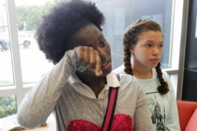  Tri'ana Jackson,13, left, wipes a tear away as she and Ciarrah Bryson, 14, explain security...