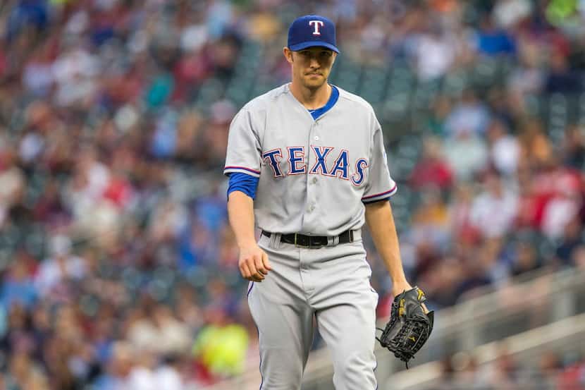 May 27, 2014; Minneapolis, MN, USA; Texas Rangers starting pitcher Scott Baker (25) walks...
