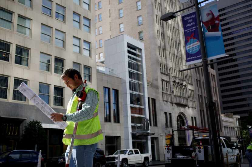 Jesse Gerich surveys as Oncor is preparing a GPS grid of its facilities in downtown Dallas...