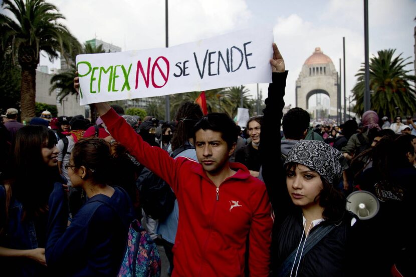 A couple held up a banner about Mexico's state-owned oil company that says "PEMEX is not for...