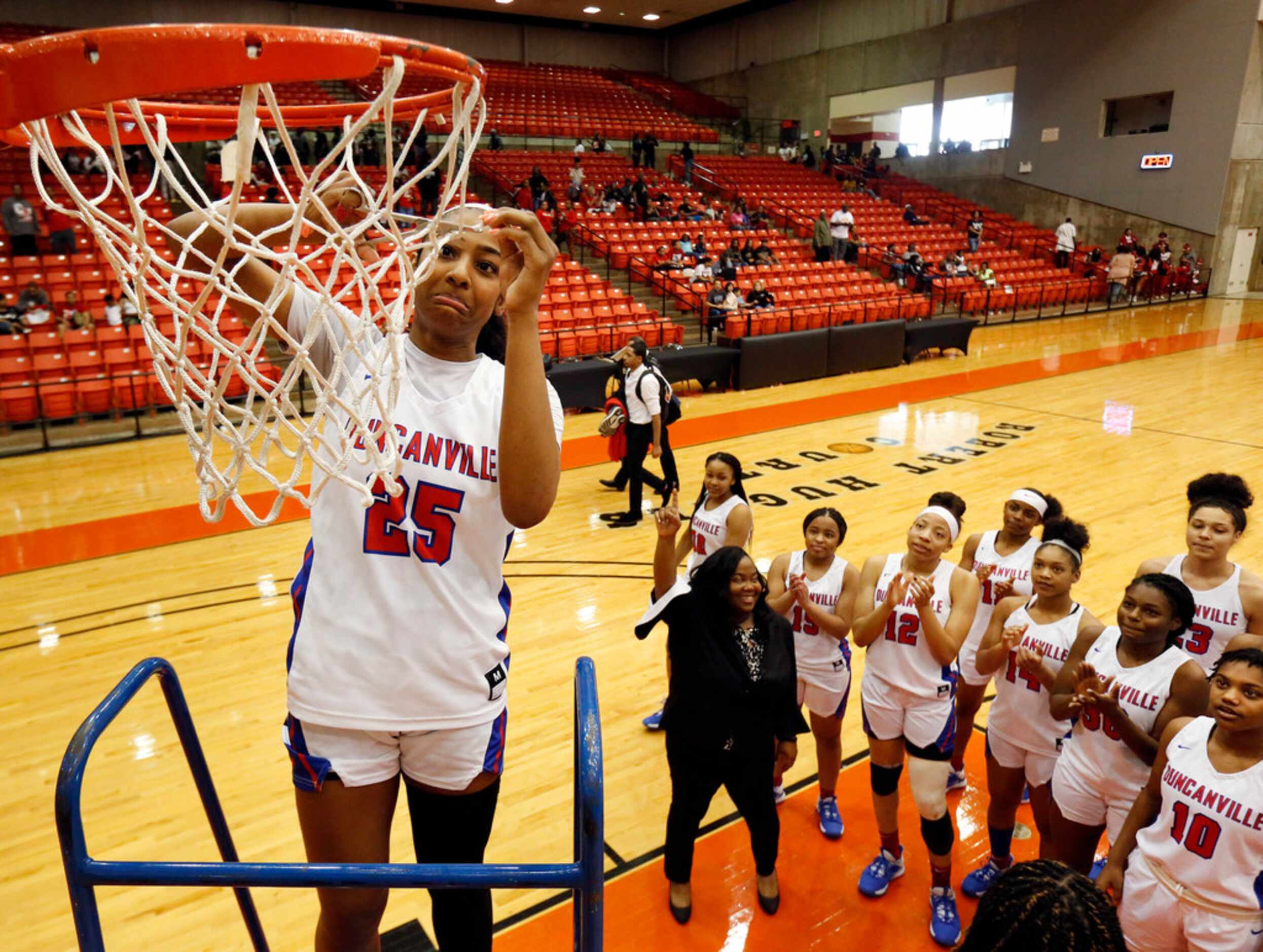 Duncanville's Deja Kelly (25) cuts a piece of the net after she and her teammates defeated...