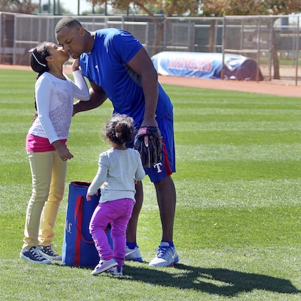 Texas Rangers third baseman Adrian Beltre gets a kiss from daughter Cassie, 9, left, as...