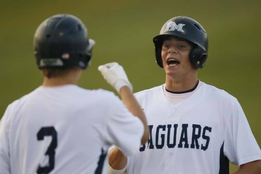 Flower Mound's Connor Wanhanen is greeted by teammate Tim Millard as he scores a run during...