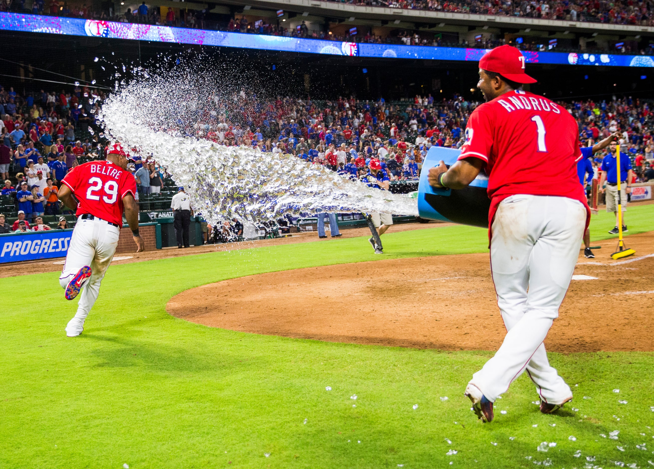 Texas Rangers third baseman Adrian Beltre (29) runs away from a Gatorade dump by shortstop...