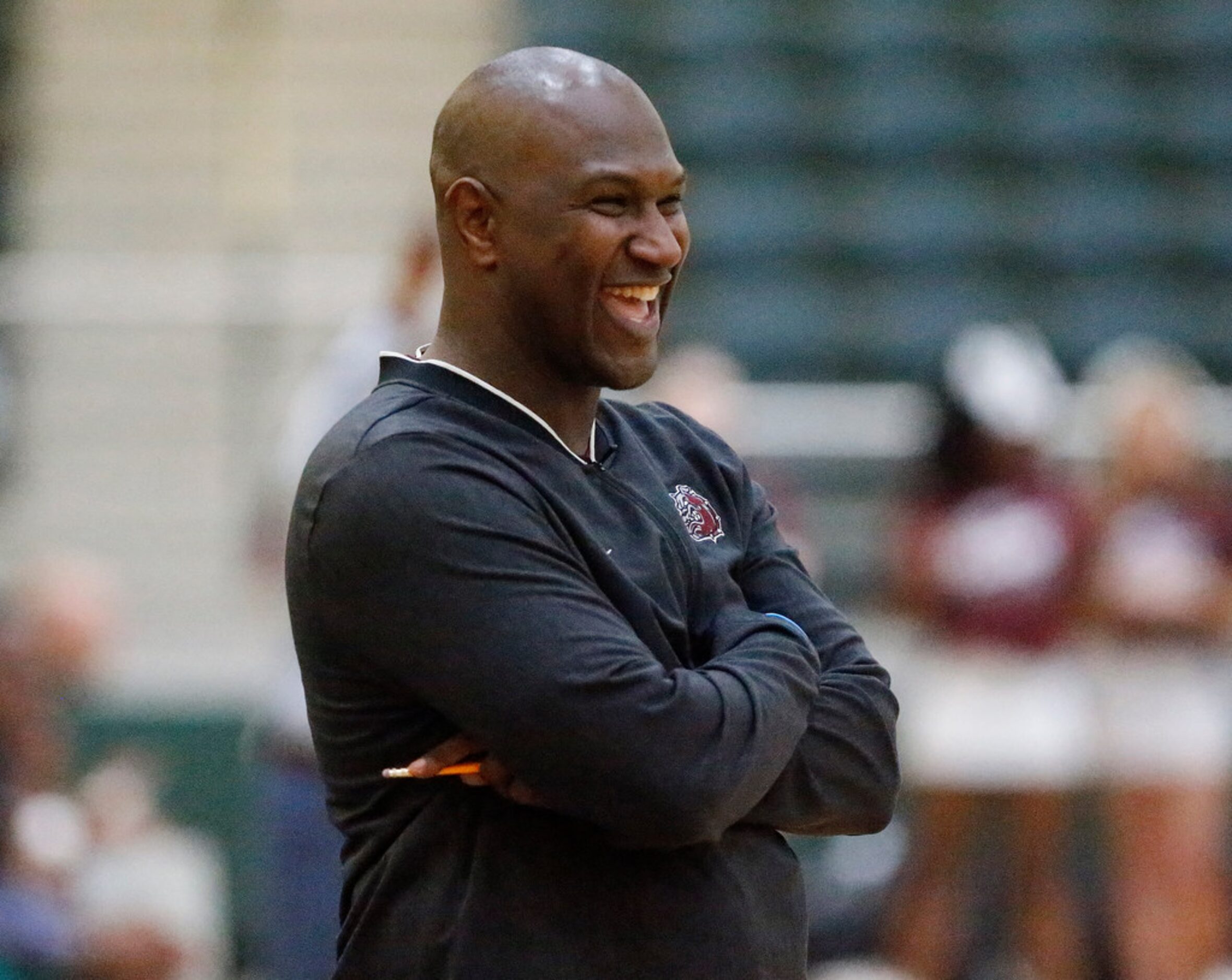 Jefferson High School head coach Treston Dowell jokes with his players before the start of...