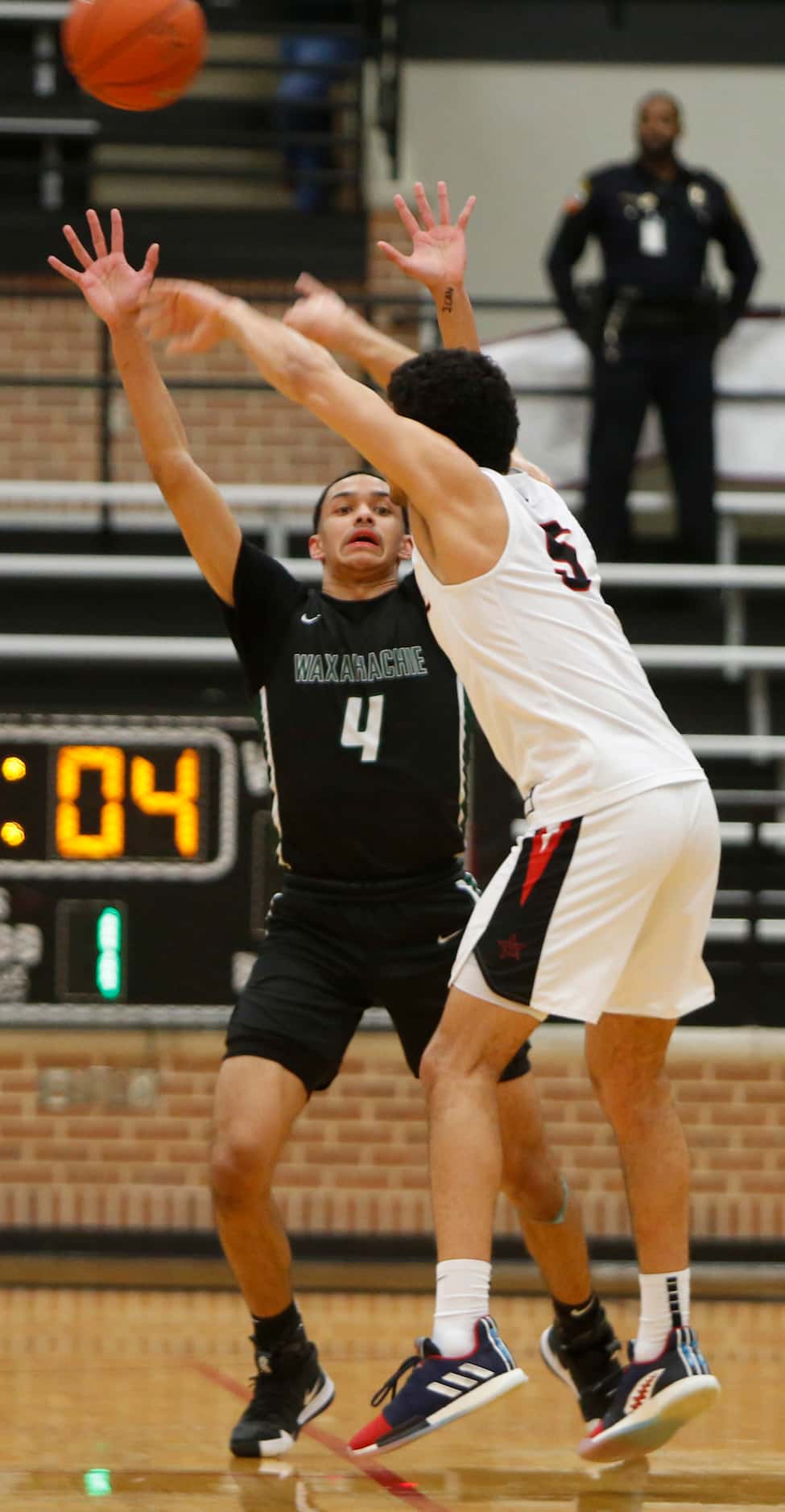 Coppell guard Adam Moussa (5) launches a cross-court pass as he is defended by Waxahachie...
