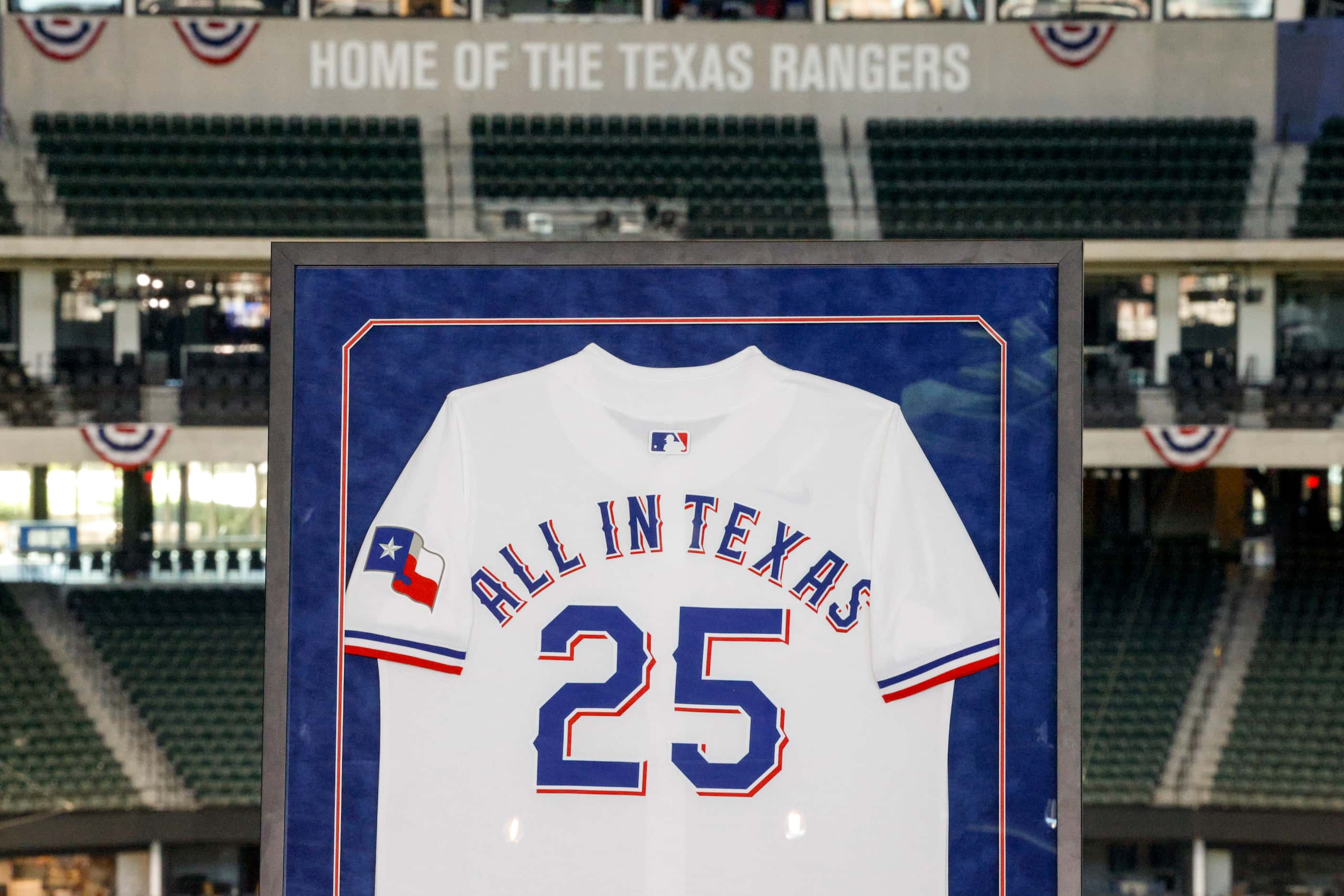 A Texas Rangers jersey printed with the name of an AEW pay-per-view event, All in Texas, is...