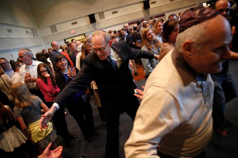 Rabbi Stefan Weinberg encourages congregants to dance in celebration of the arrival of the...