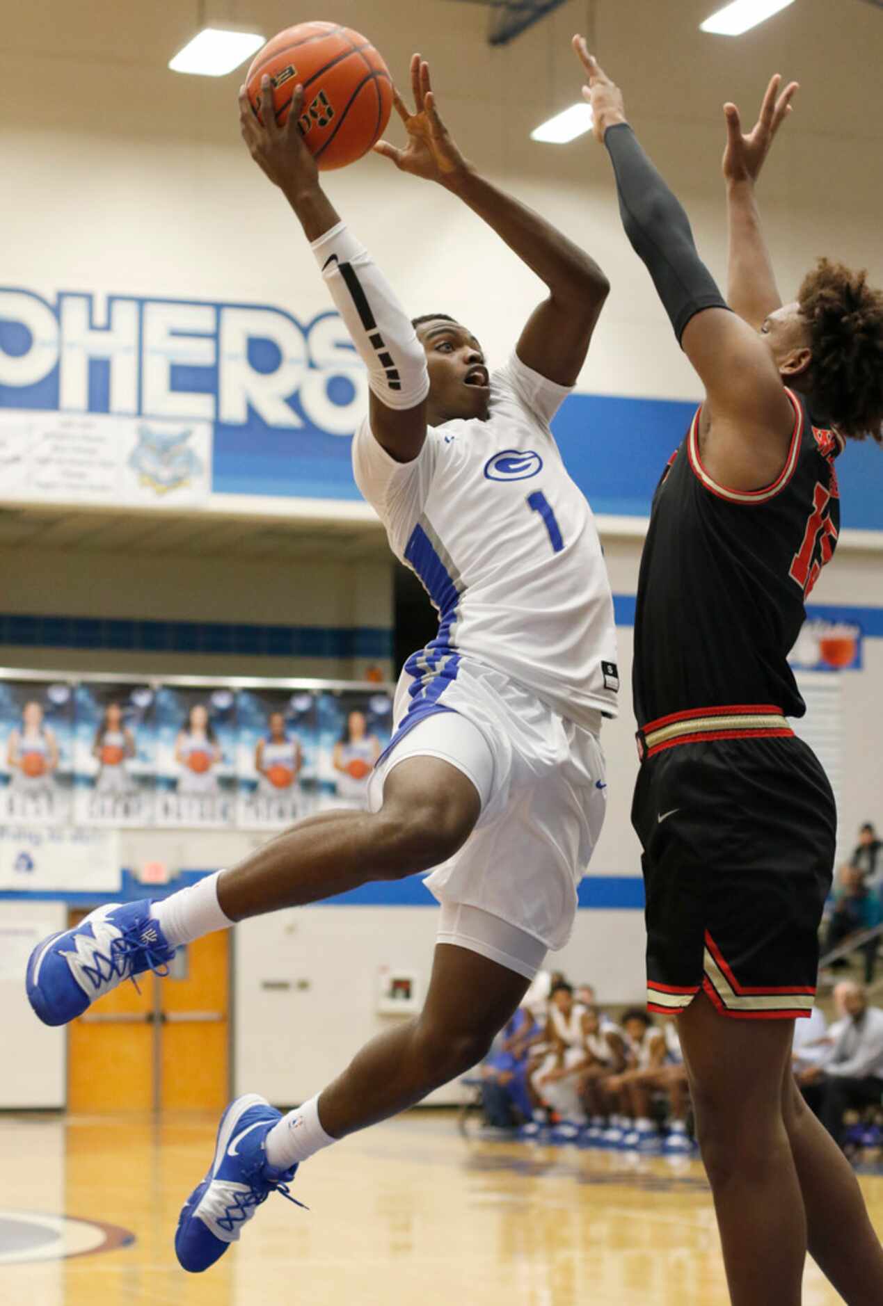 Grand Prairie's Jaylin Posey (1) skies to the basket against the defense of South Grand...