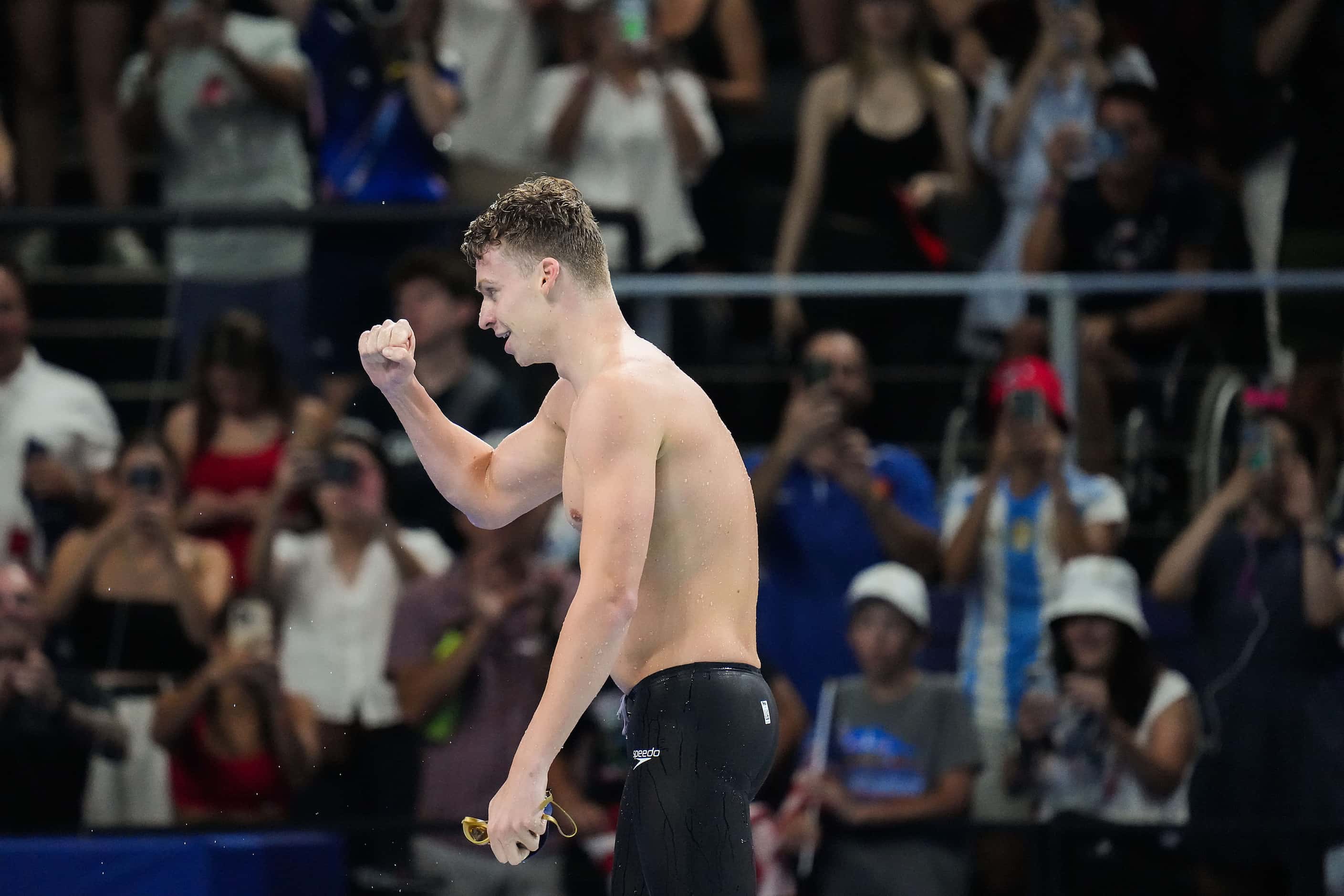Fans cheer Leon Marchand of France celebrates after winning the men’s 200-meter breaststroke...