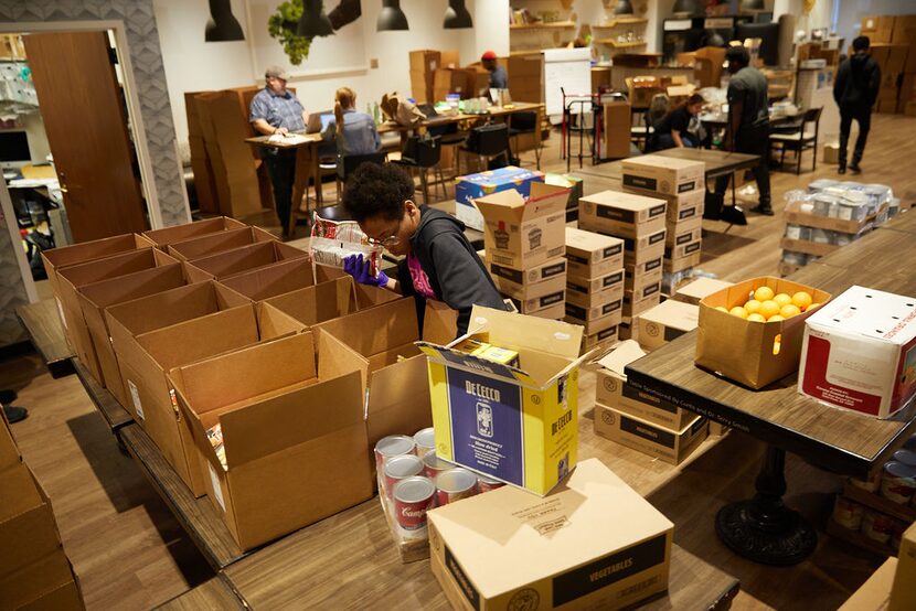 Interns at Cafe Momentum in downtown Dallas box up food for needy families.