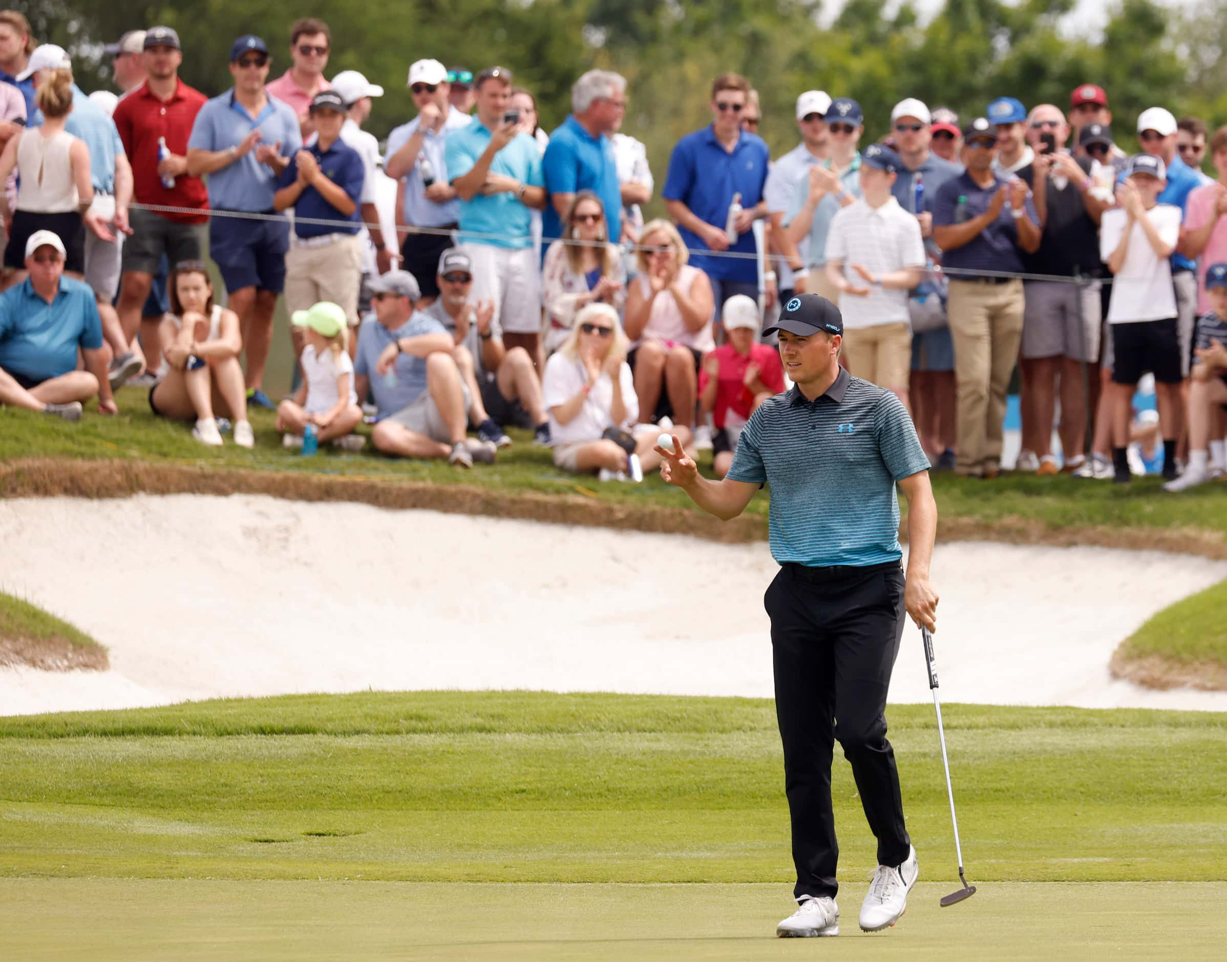 Jordan Spieth acknowledges the crowd after getting a birdie on the 12th hole during round 3...