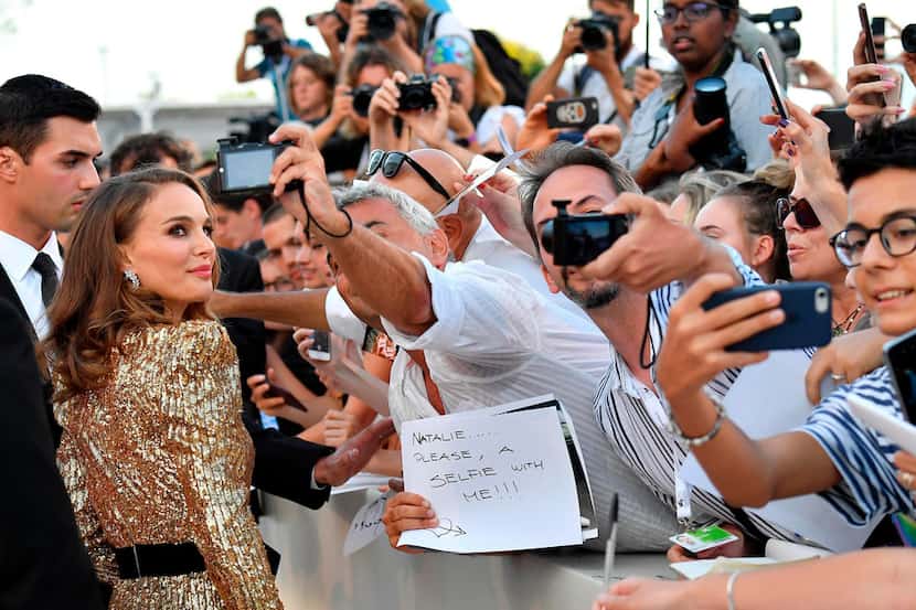 Actress Natalie Portman signed autographs and posed for a photo as she arrived for the...