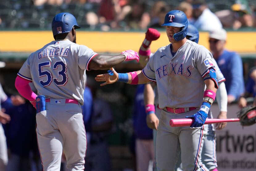 Texas Rangers' Adolis Garcia (53) is congratulated by Josh Jung after hitting a grand slam...
