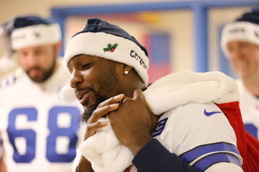 Dallas Cowboys wide receiver Dez Bryant carries a sack of gifts for patients during a visit...