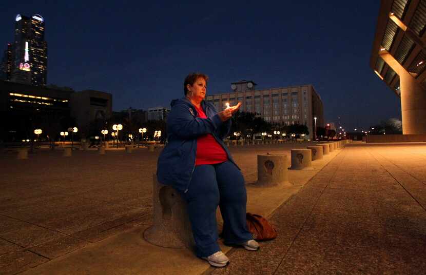 Sara Horton holds a candle for her daughter, Karen Cox Smith, who was killed by her...