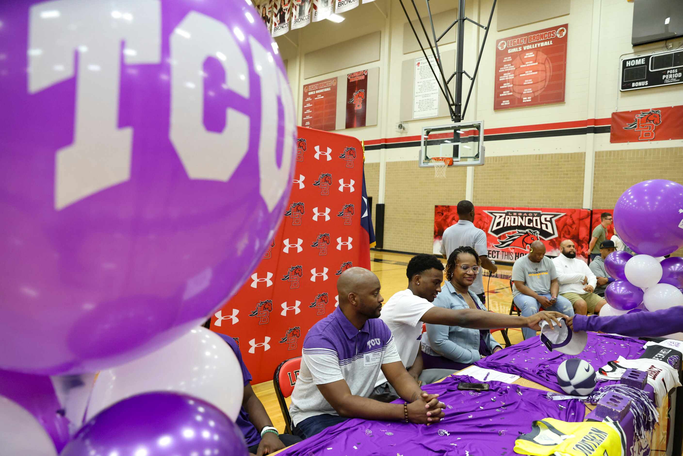 Isaiah Manning grabs a Texas Christian University hat during his signing day Wednesday, Nov....