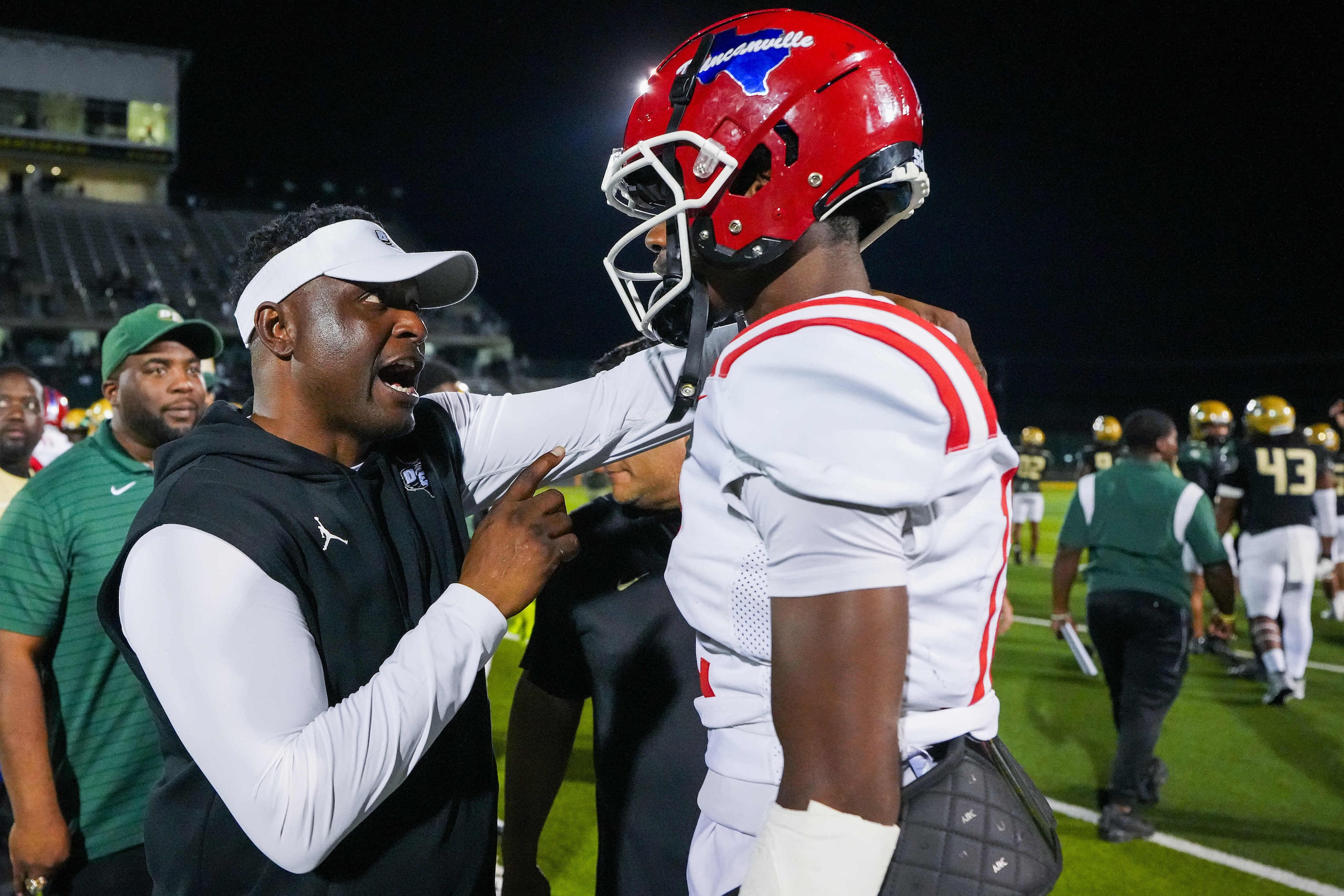 DeSoto head coach Claude Mathis talks with Duncanville quarterback Keelon Russell after...